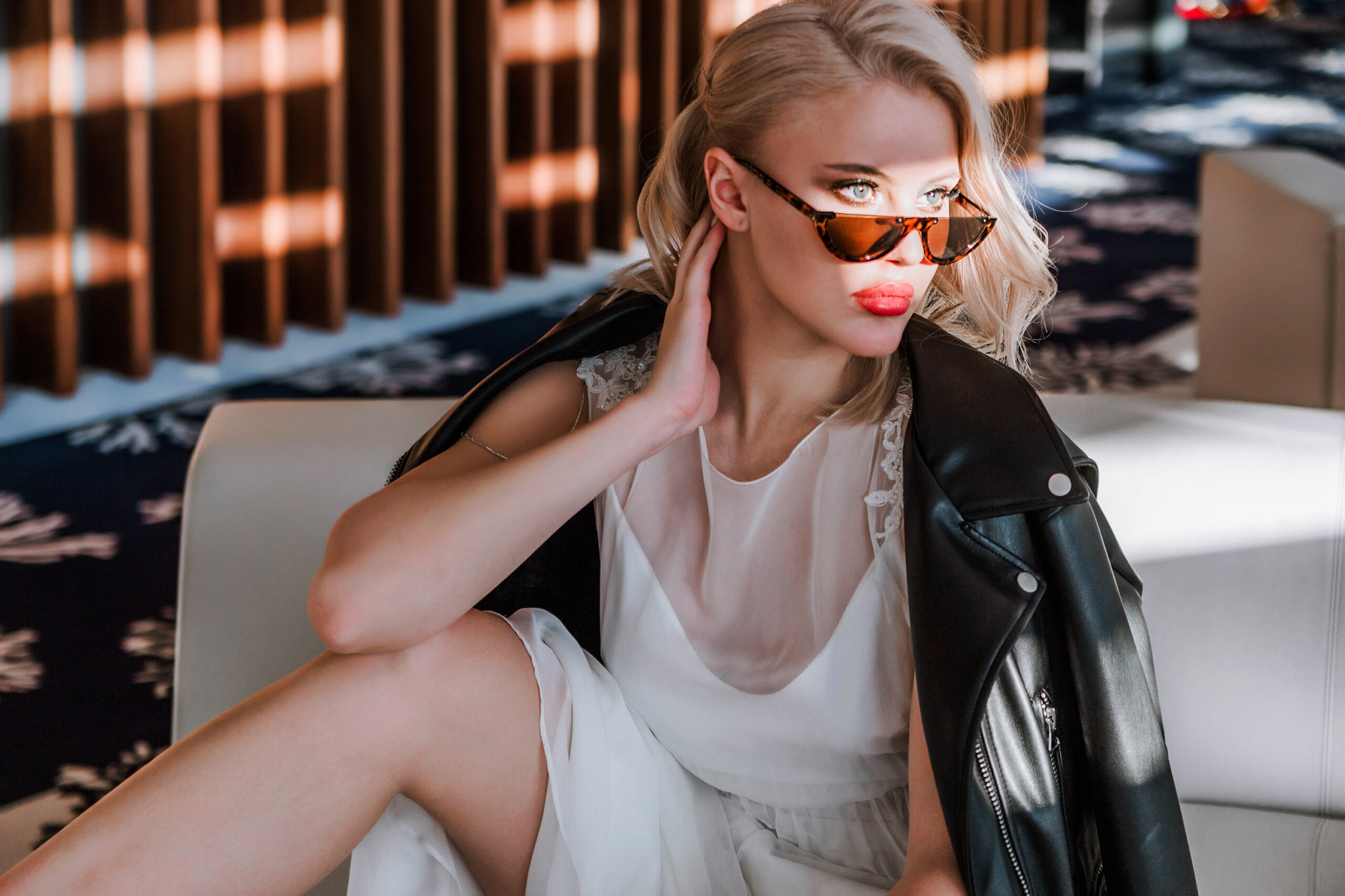 Beautiful blonde young bride woman in white wedding dress, black leather jacket and sunglasses. Rock style, fashion beauty photo