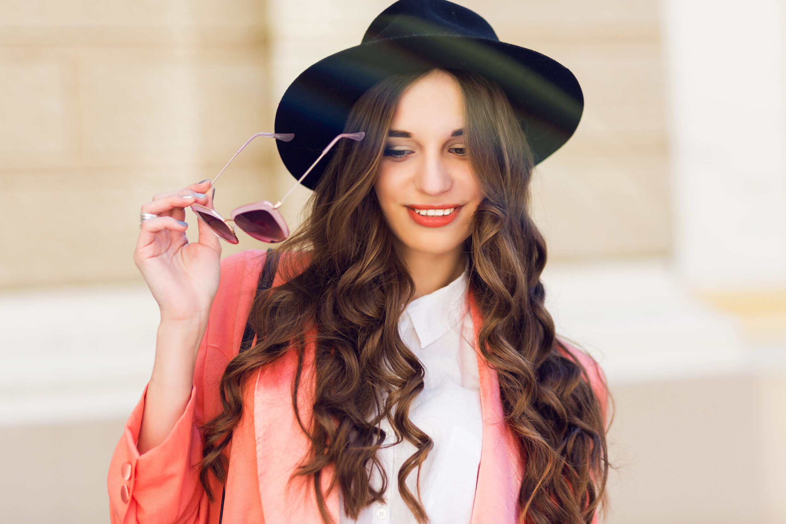 Close up  outdoor portrait of fashionable pretty woman   in casual bright spring or summer outfit , looking at camera, laughing.  Brunette  curly hairstyle. Bright sunny colors.